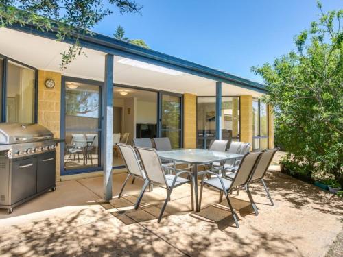 a patio with a table and chairs and a grill at Stones Throw To The Beach in Tootgarook