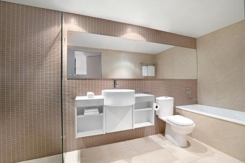 La salle de bains est pourvue de toilettes, d'un lavabo et d'une baignoire. dans l'établissement Mantra Pandanas, à Darwin