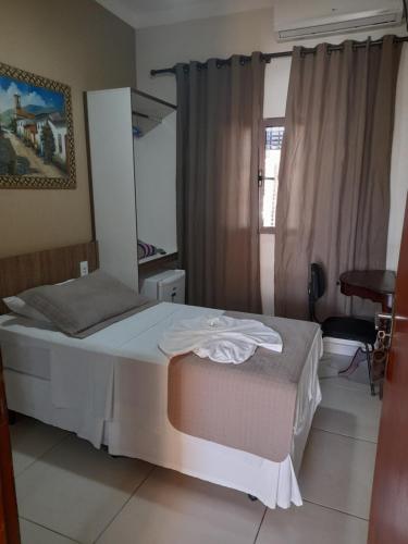 una camera con un grande letto e una finestra di Hotel Cheffer a Porto Ferreira