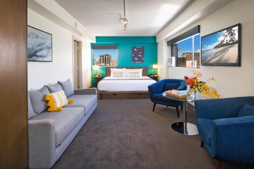 a hotel room with a bed and a couch at VIVE Hotel Waikiki in Honolulu