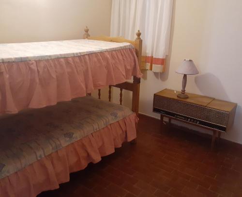 een slaapkamer met 2 bedden en een tafel met een lamp bij Casa Elisa in Ciudad Lujan de Cuyo