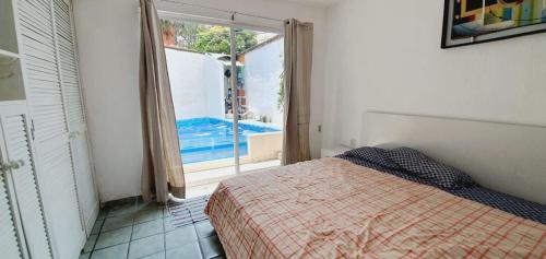 a bedroom with a bed and a view of a pool at FABULOSA CASA Centro Cuernavaca Alberca Privada Climatizada in Cuernavaca