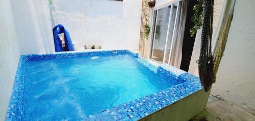 a large blue tub in a room with a window at FABULOSA CASA Centro Cuernavaca Alberca Privada Climatizada in Cuernavaca