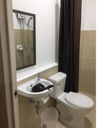 a bathroom with a sink and a toilet and a mirror at Bria Flats/Codo in Cagayan de Oro