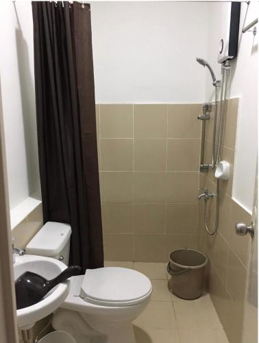 a bathroom with a toilet and a sink and a shower at Bria Flats/Codo in Cagayan de Oro
