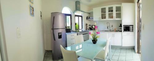 a kitchen with a stainless steel refrigerator and white cabinets at FABULOSA CASA Centro Cuernavaca Alberca Privada Climatizada in Cuernavaca