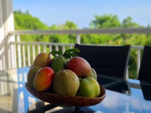 a bowl of fruit sitting on a glass table at Residence Can' Hibiscus in Le Marin
