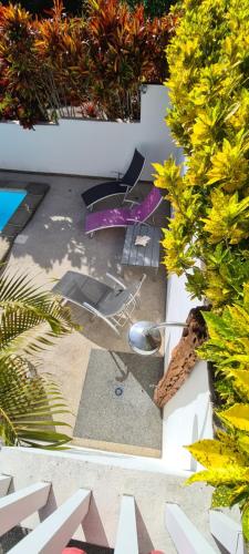 a view of a patio with chairs and a pool at Residence Can' Hibiscus in Le Marin