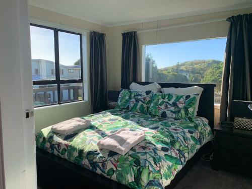 a bedroom with a bed and a large window at Sand Dunes Retreat in Otaki Beach