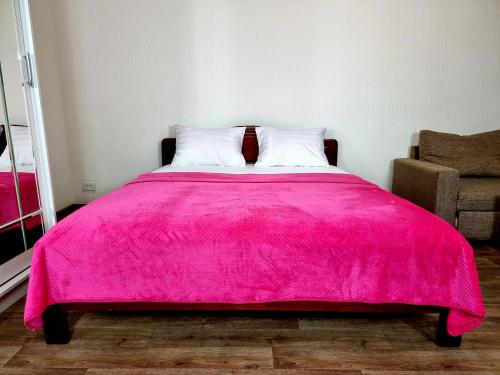 モスクワにあるApartamenty RoomOnDay Beringov 4のピンクベッド1台(枕2つ、ピンクの毛布付)