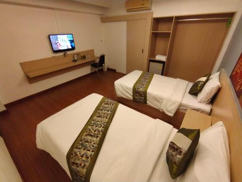 ein Hotelzimmer mit 2 Betten und einem TV in der Unterkunft Aileen Hotel in Khon Kaen