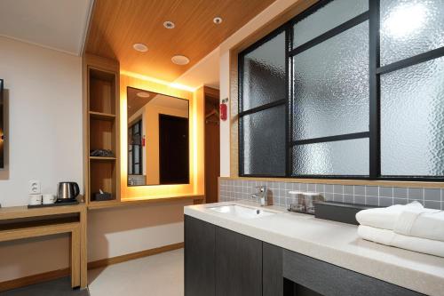 baño con lavabo y ventana grande en S Stay Hotel, en Suwon