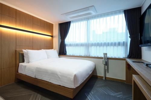 une chambre d'hôtel avec un lit et une fenêtre dans l'établissement S Stay Hotel, à Suwon