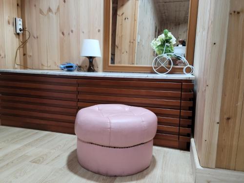 a pink ottoman in front of a counter with a mirror at Jeju Vision House in Jeju