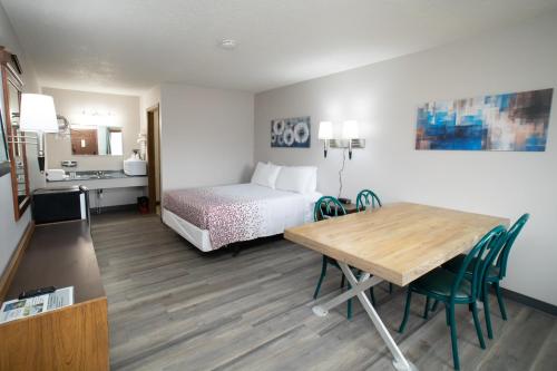 ein Hotelzimmer mit einem Bett und einem Tisch mit Stühlen in der Unterkunft Shady Rest Motel in Arapahoe