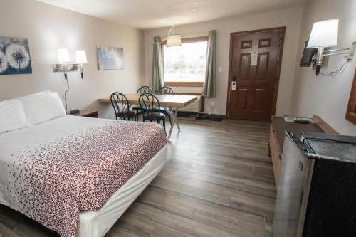 a bedroom with a bed and a table with chairs at Shady Rest Motel in Arapahoe
