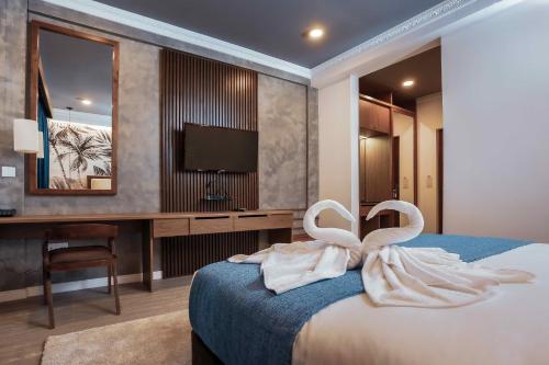two swans are sitting on a bed in a hotel room at Beach & Bliss Mirissa in Mirissa