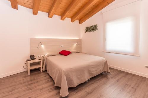 ein Schlafzimmer mit einem Bett mit einem roten Kissen darauf in der Unterkunft Hotel Ristorante Cigno in Latisana