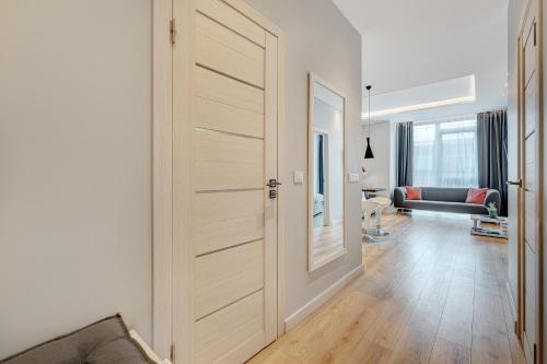 a large wooden door in a living room with a couch at HaPPy Inn Emporia, Self chek-in, Parking in the underground garage in Vilnius