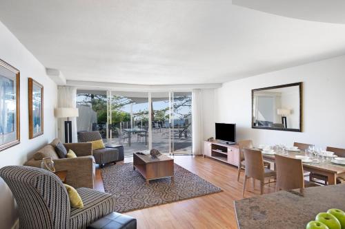 a living room with a table and a dining room at Mantra Zanzibar in Mooloolaba