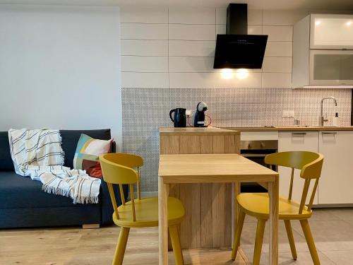 cocina con mesa y 2 sillas amarillas en Comfortable apartments Warsaw West III, en Varsovia