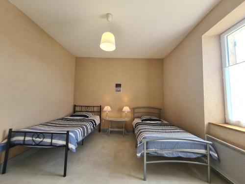 2 Betten in einem Zimmer mit einem Tisch und einem Fenster in der Unterkunft Gîte Migné, 3 pièces, 4 personnes - FR-1-591-316 in Migné