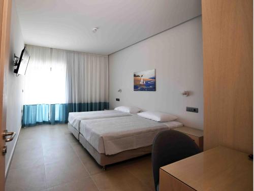 ein Hotelzimmer mit einem Bett und einem Fenster in der Unterkunft MIRAMARE LUXURY APARTMENTS in Eretria