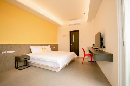 馬公市的住宿－向日葵精緻旅店，一间卧室配有一张床、一张书桌和一台电视
