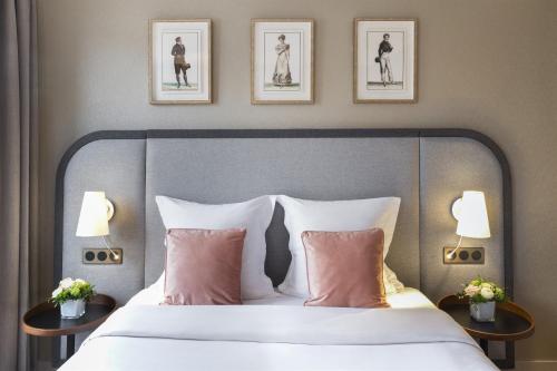 a bed with two pillows and a picture on the wall at Warwick Reine Astrid - Lyon in Lyon