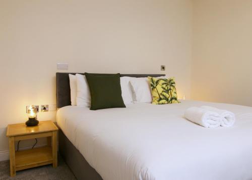 a bedroom with a large white bed with a night stand at Escape Ordinary at Castle Hume in Enniskillen