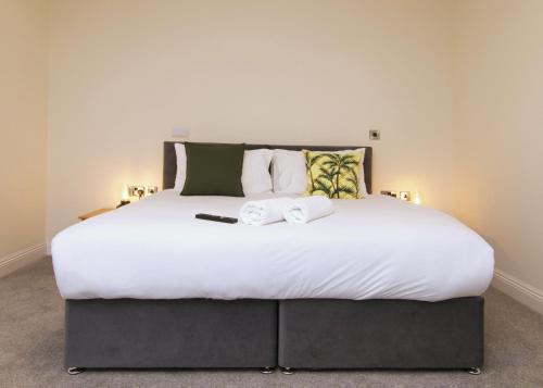 a large white bed with two towels on it at Escape Ordinary at Castle Hume in Enniskillen