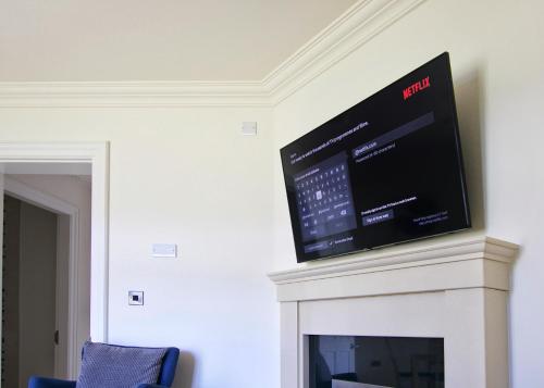 a flat screen tv on top of a fireplace at Escape Ordinary at Castle Hume in Enniskillen