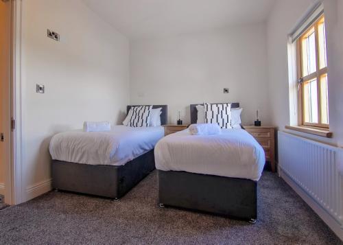 two beds sitting next to each other in a room at Escape Ordinary at Castle Hume in Enniskillen