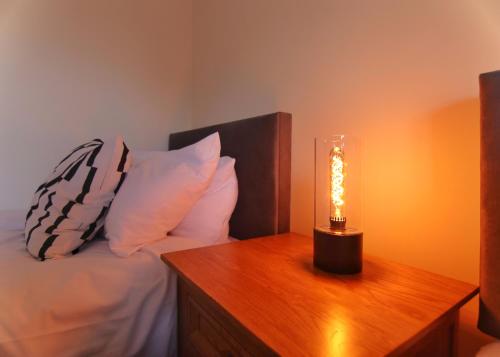 a bedroom with a bed and a lamp on a table at Escape Ordinary at Castle Hume in Enniskillen