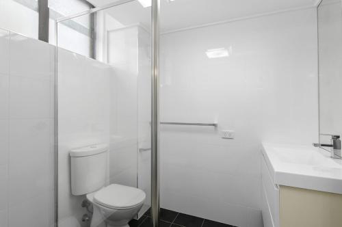 Un baño con inodoro y ducha de cristal. en Holiday Central, Tasman Towers Unit 2, 3 Munster Street,, en Port Macquarie