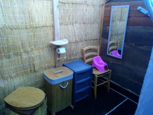 a bathroom with two toilets and a sink and a mirror at Yourte et tente dans un écolieu avec piscine hors-sol in Péault