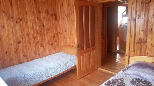 Habitación con cama y puerta abierta en Біля лісу (Апартаменти для сім'ї), en Slavske