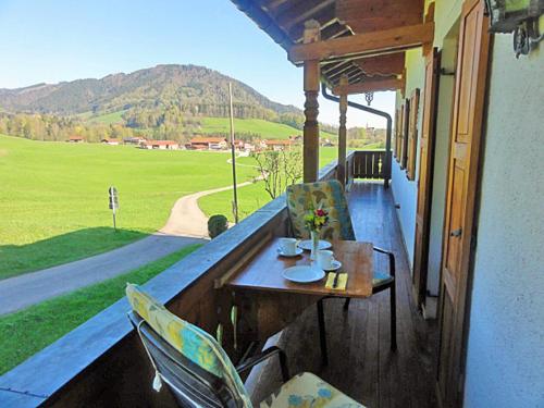 a table and chairs on a porch with a view at Ferienwohnung Beim Raffner in Ruhpolding
