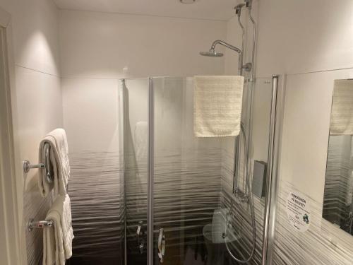 a shower with a glass door in a bathroom at Hotell TunaPark in Eskilstuna