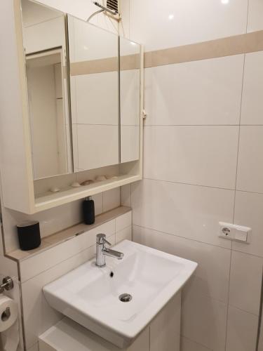 a white bathroom with a sink and a mirror at Ferienwohnung Finkenweg in Bad Neuenahr-Ahrweiler