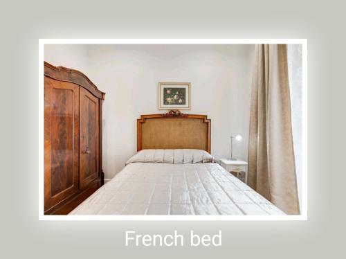 ローマにあるEluta Holiday Homeのベッドルーム1室(ベッド1台、木製ヘッドボード付)