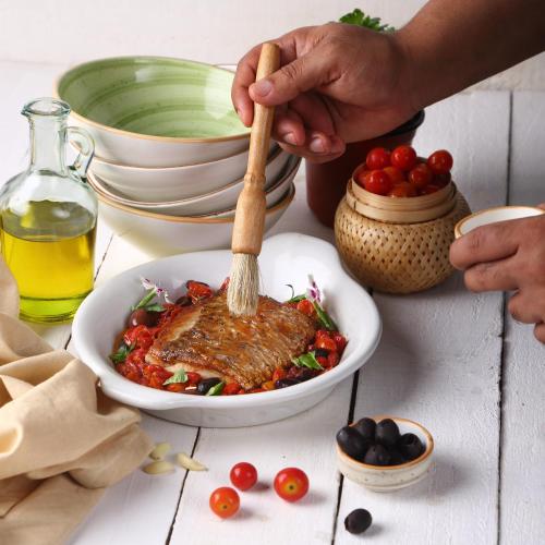 a person stirring a bowl of food with a wooden spoon at Park Hyatt Hotel and Residences, Hyderabad in Hyderabad