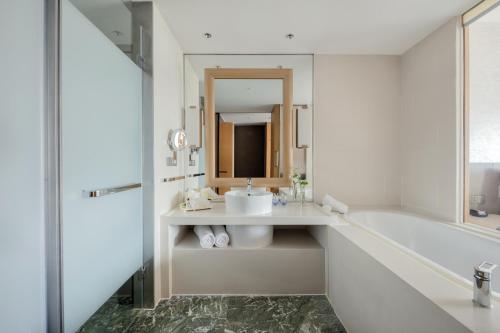 a bathroom with a sink and a tub and a mirror at InterContinental Suzhou Hotel by IHG in Suzhou