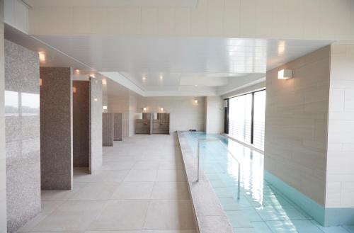 a hallway with a swimming pool in a building at Kawasaki King Skyfront Tokyu REI Hotel in Kawasaki