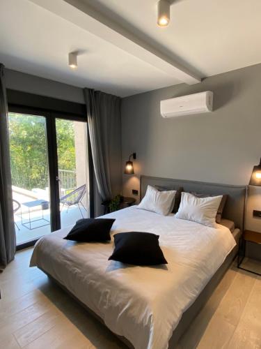 a bedroom with a large bed with two pillows on it at Villa Anthea Paola in Nedeščina