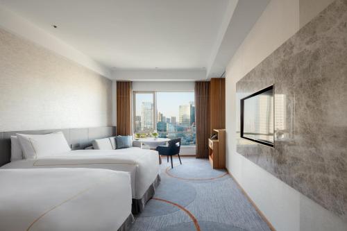 ein Hotelzimmer mit 2 Betten und einem Fenster in der Unterkunft InterContinental Suzhou Hotel, an IHG Hotel in Suzhou