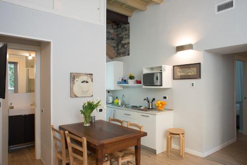 eine Küche und ein Esszimmer mit einem Tisch und Stühlen in der Unterkunft La Corte di Zizi in Cernobbio