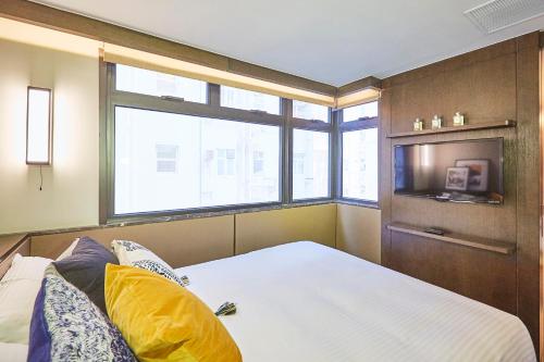 a bedroom with a bed and a large window at Princeton Residence in Hong Kong