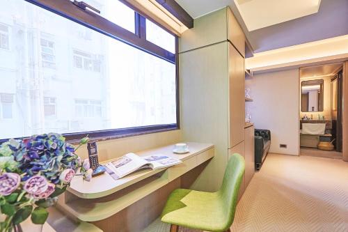 a room with a desk and a green chair and a window at Princeton Residence in Hong Kong