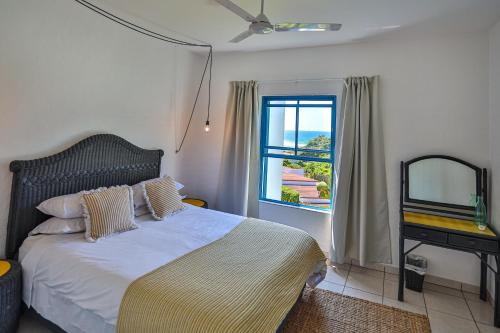 um quarto com uma cama grande e uma janela em Serenity At Sea - Santorini Estate - FAMILY ONLY em Ballito
